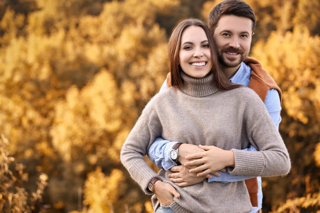 Beautiful couple spending time together outdoors on autumn day